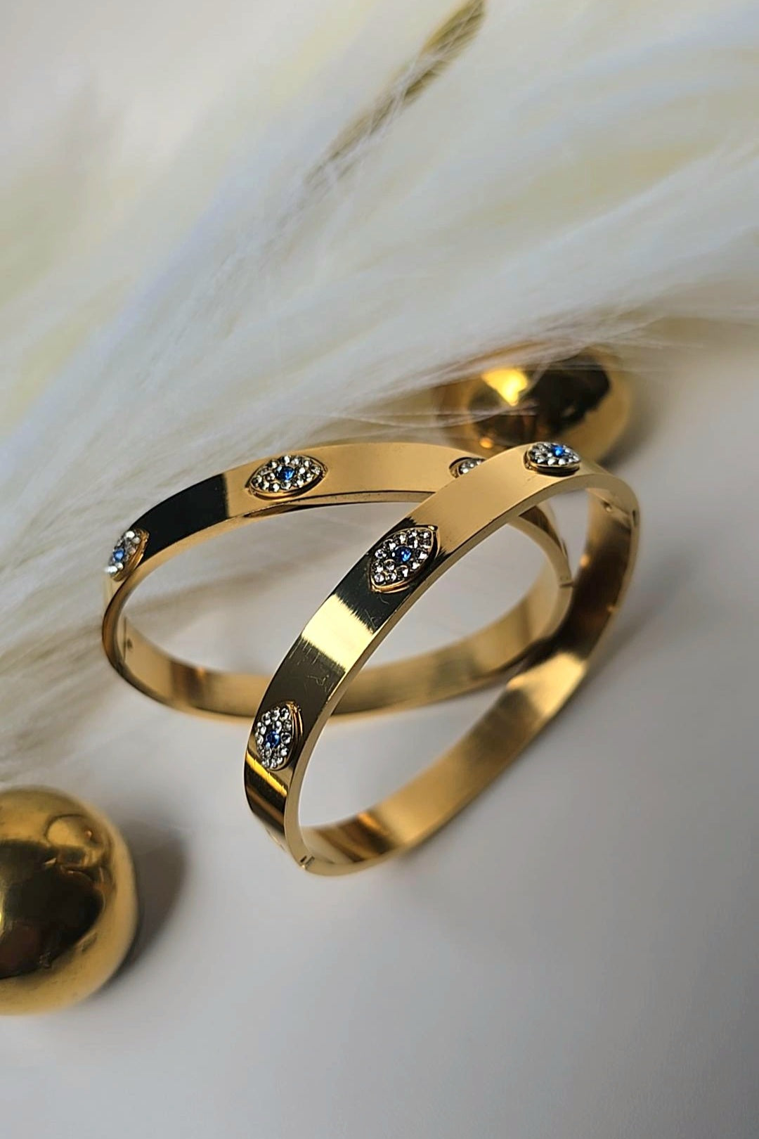 Gold bracelet with embedded stones on a soft white background