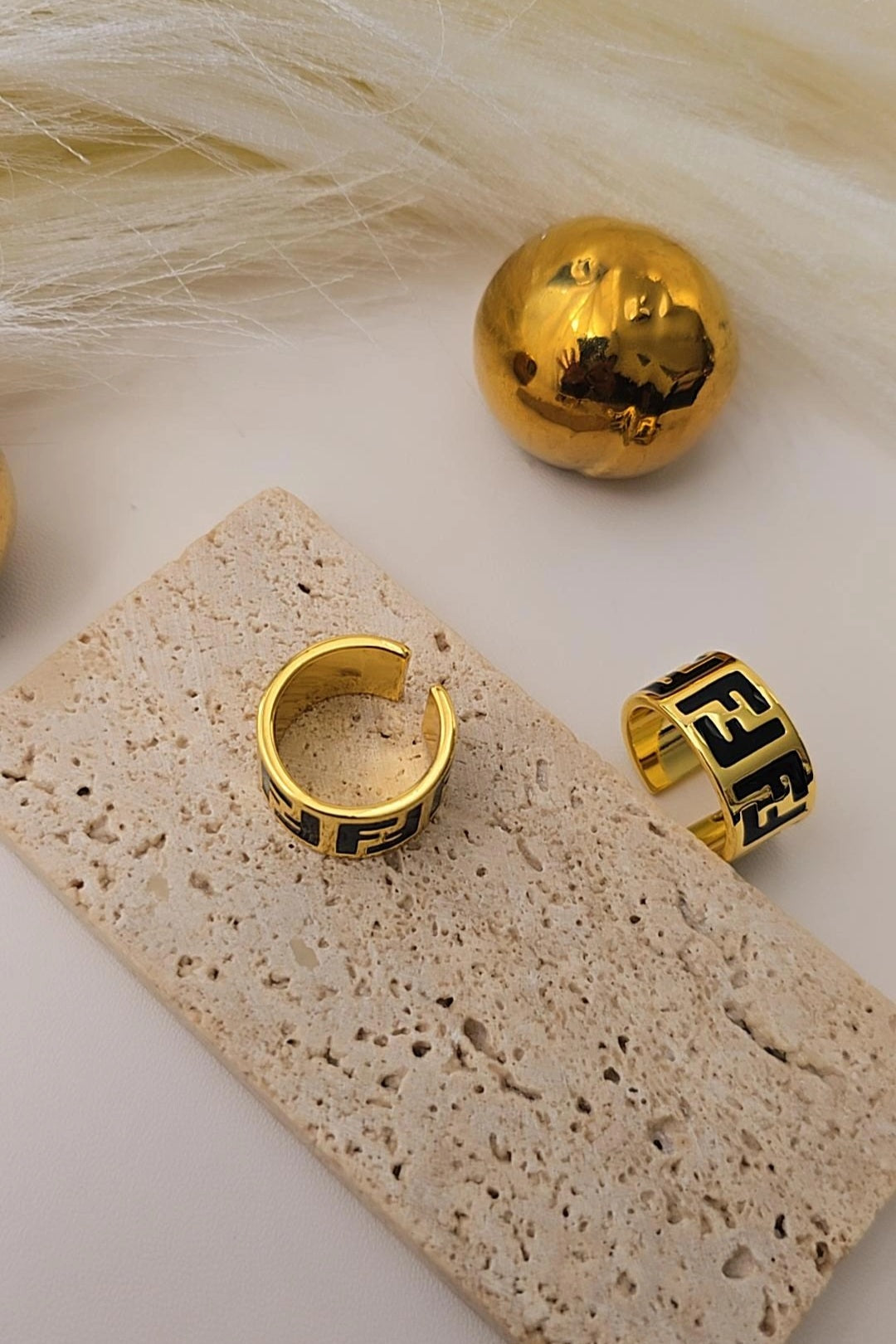 Gold hoop earrings with black geometric design