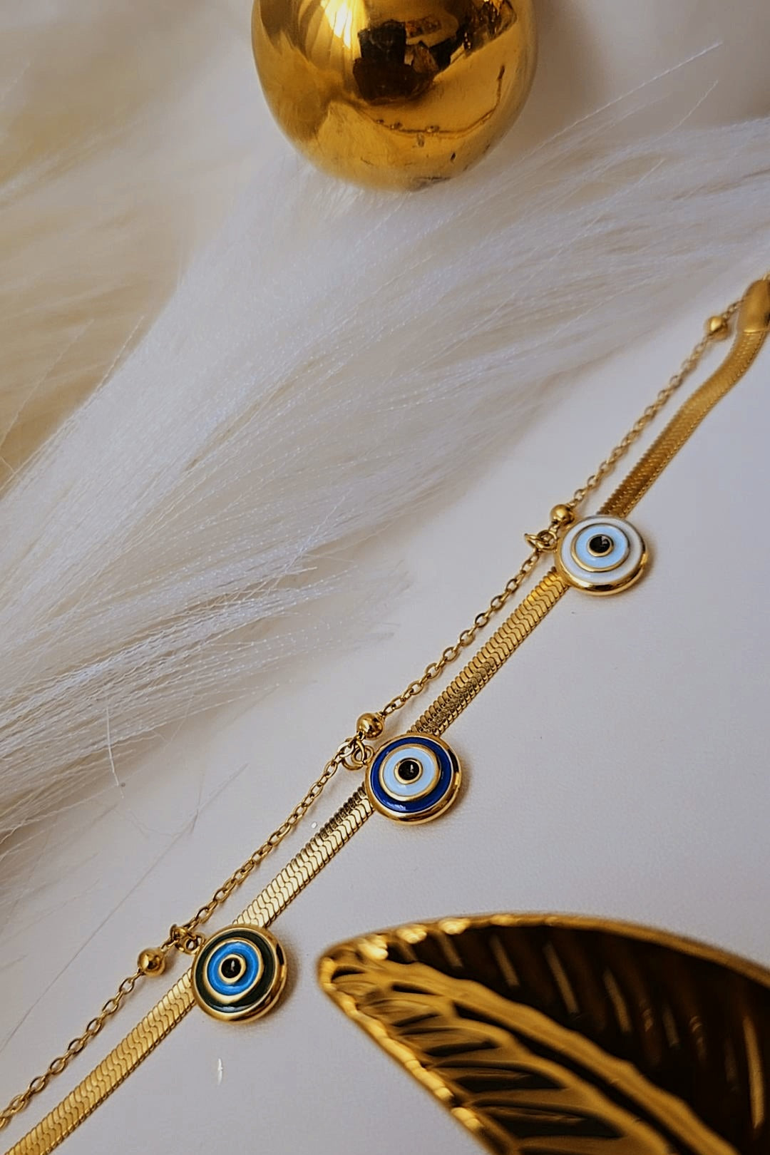 Gold bracelet with blue eye charms