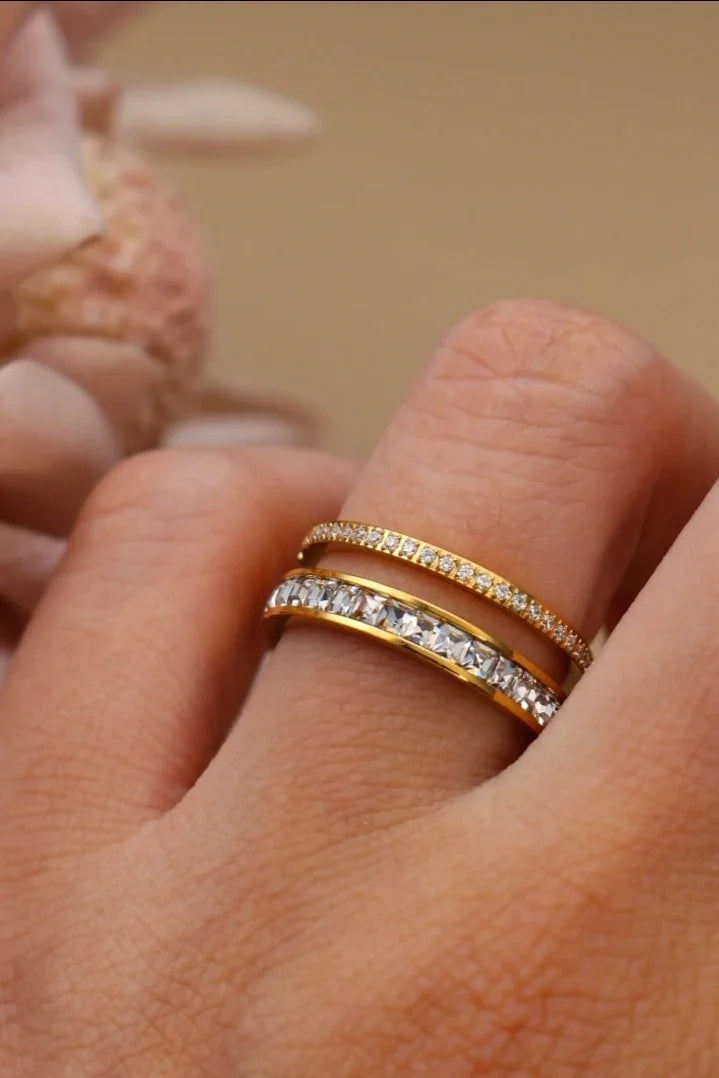 Gold rings with sparkling stones on finger, Bliss Bymi jewelry, close-up