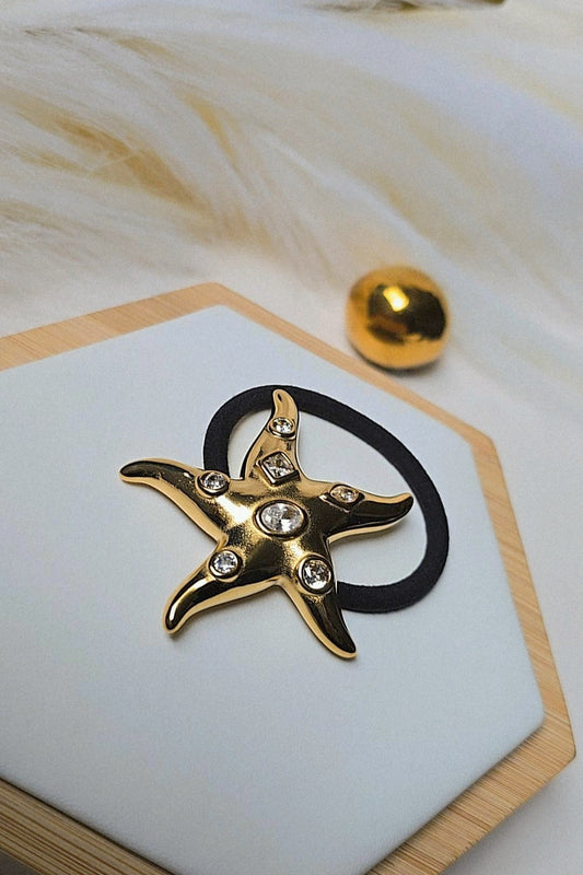 Gold star-shaped brooch with gemstones